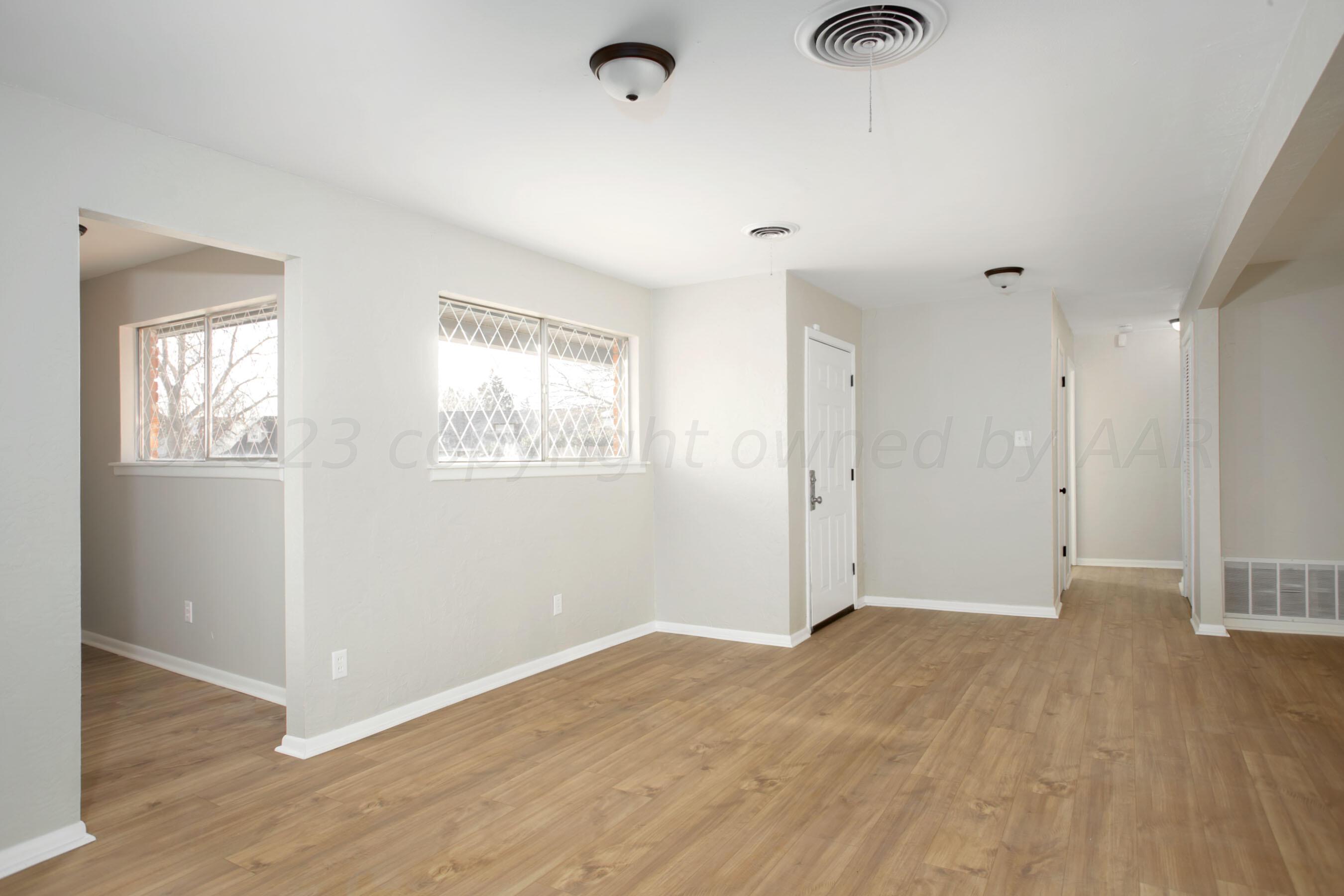 3624 Sunlite Street Amarillo, TX 79109 - Photo 9 of 25 an empty room with wooden floor and windows