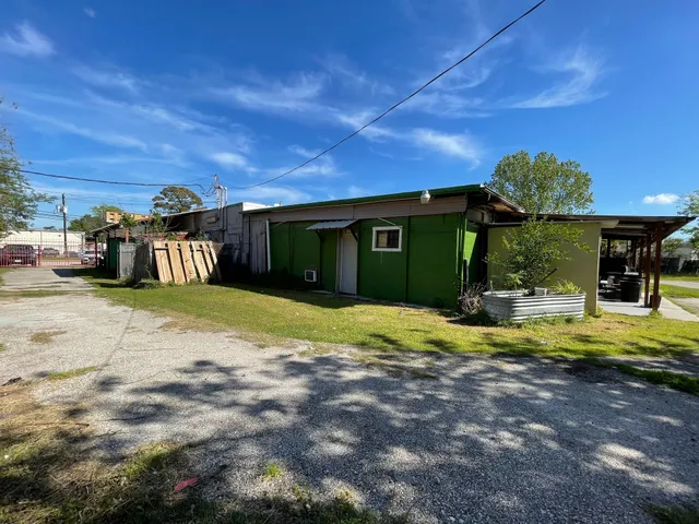 a view of swimming pool with lawn chairs and plants