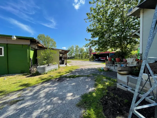 a view of a house with backyard and trees