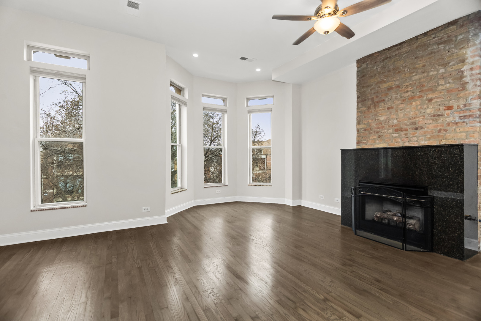 2247 West Monroe Street, Unit 3 Chicago, IL 60612 - Photo 7 of 31 a view of an empty room with wooden floor fireplace and a window