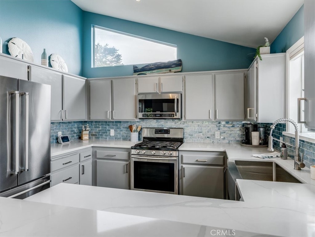 554 Cambridge Street Cambria, CA 93428 - Photo 17 of 52 a kitchen with white cabinets and stainless steel appliances