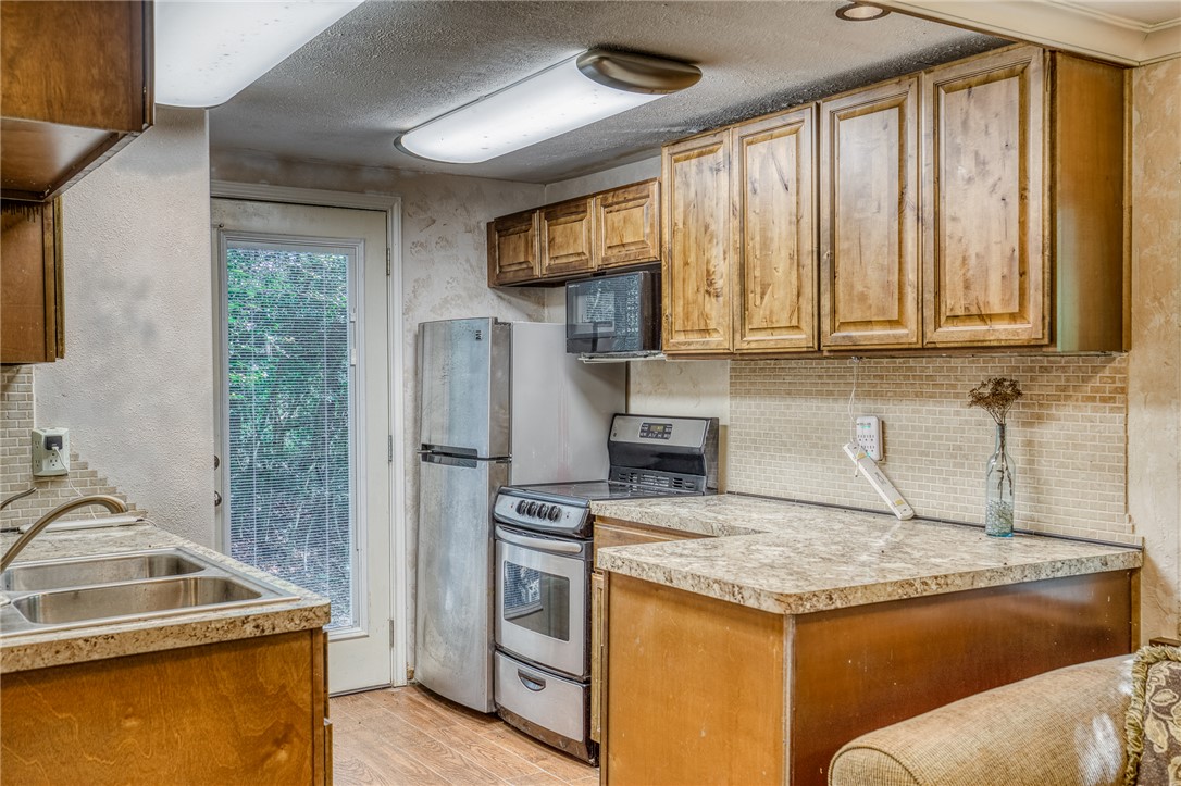 2330 County Road 329 Milano, TX 76556 - Photo 17 of 45 a kitchen with a stove a sink and a microwave