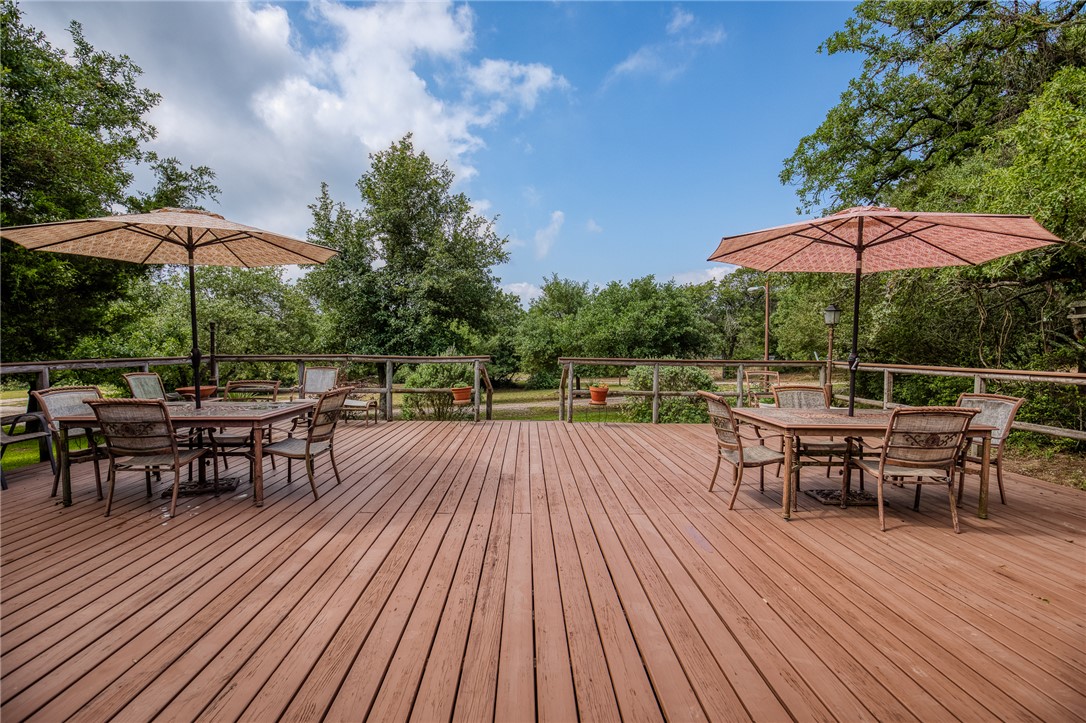 2330 County Road 329 Milano, TX 76556 - Photo 8 of 45 a view of a roof deck with table and chairs under an umbrella with wooden floor