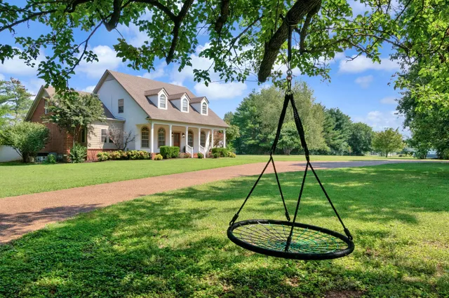 a view of a big house with a big yard and potted plants