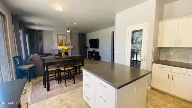 a kitchen with a dining table chairs and white appliances