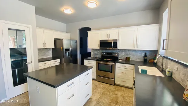 a kitchen with a sink a microwave a refrigerator and cabinets