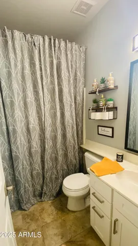 a bathroom with a sink a toilet and shower curtain