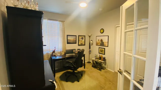 a view of a livingroom with workspace and a window