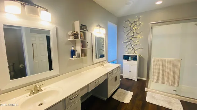 a bathroom with a double vanity sink mirror and shower