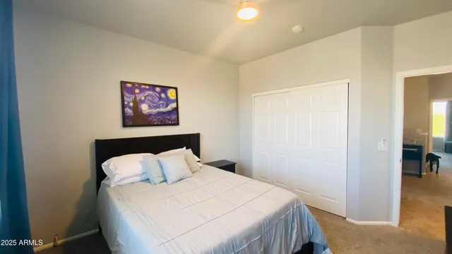 a bedroom with a bed and a painting on the wall