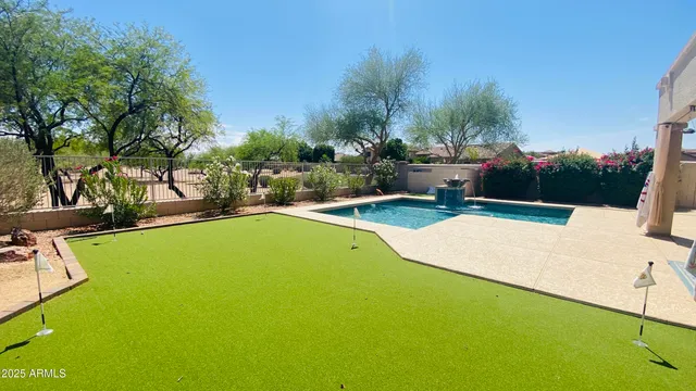 a view of a swimming pool with a bench and trees around