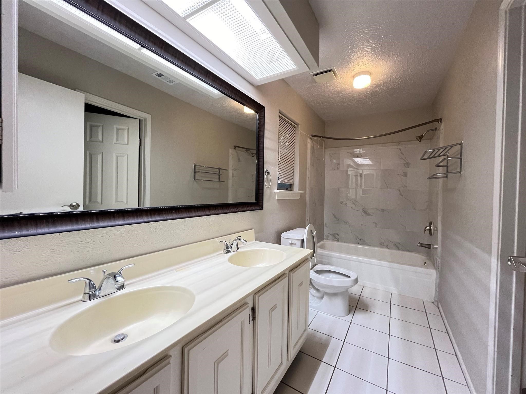 17 Briervine Court Spring, TX 77381 - Photo 12 of 19 a bathroom with a double vanity sink toilet mirror and shower