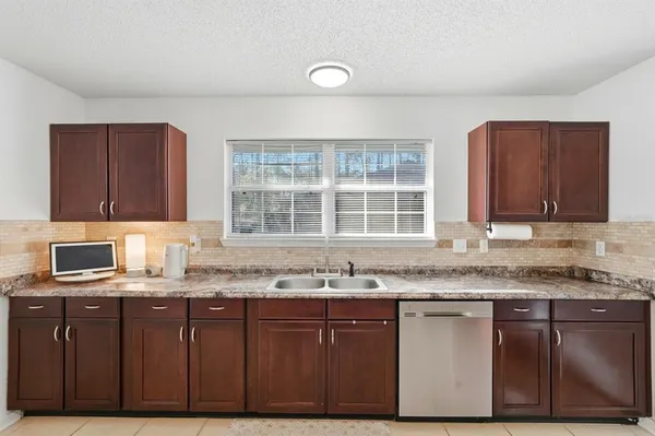 a kitchen with stainless steel appliances granite countertop a stove top oven a sink dishwasher a dining table and chairs