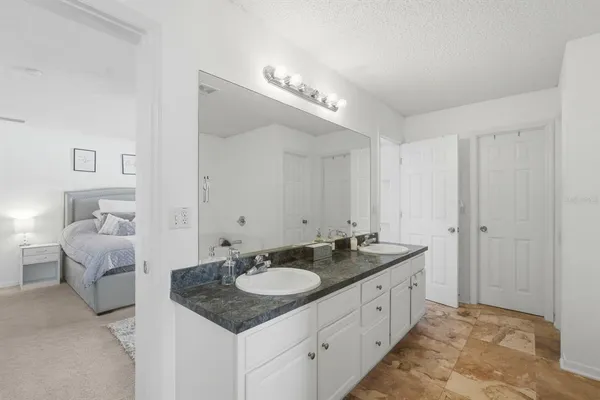 a bathroom with a granite countertop sink and mirror