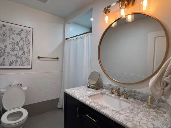 a bathroom with a granite countertop double vanity sink and a mirror