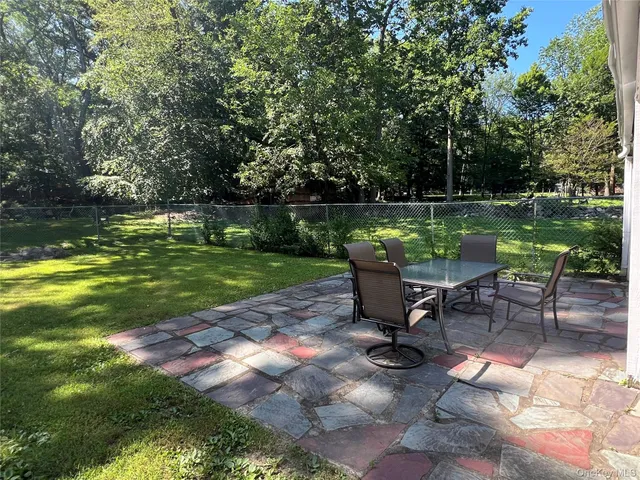 a view of a garden with chairs and a table