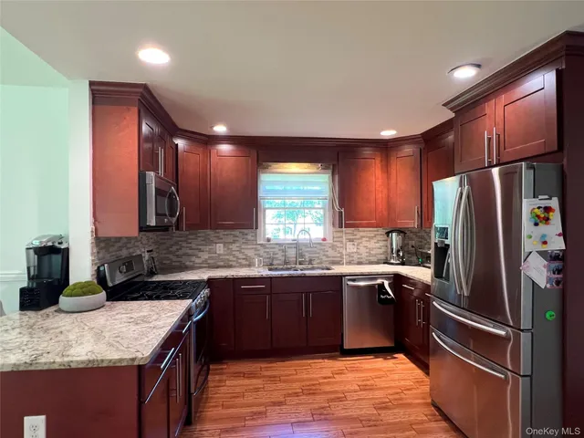 a kitchen with stainless steel appliances granite countertop refrigerator sink and cabinets