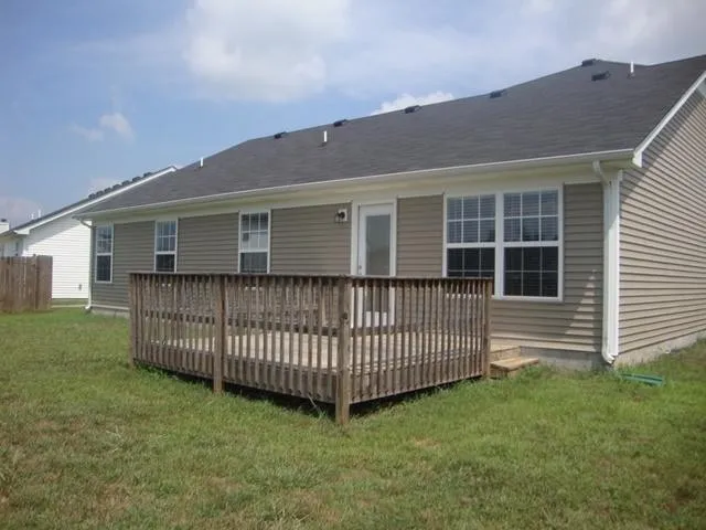 a view of backyard with deck and garden