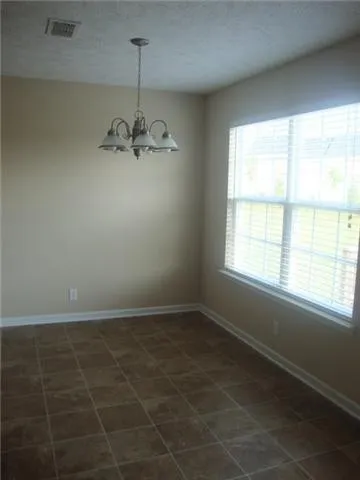 a view of a room with a chandelier fan and windows