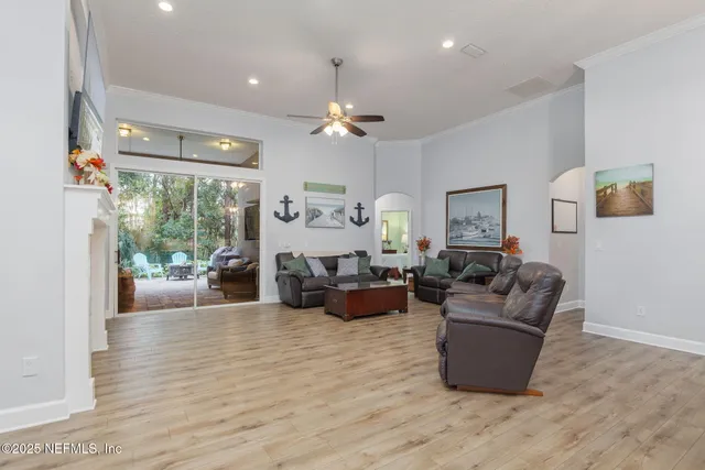 a living room with furniture kitchen view and a wooden floor