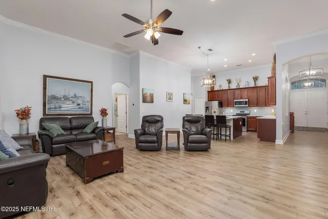 a kitchen with stainless steel appliances a sink a counter space and a living room view
