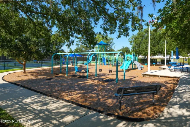 a view of a stone house with a small yard and large tree