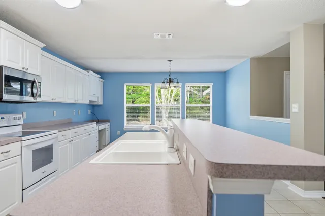 a kitchen with granite countertop white cabinets and window