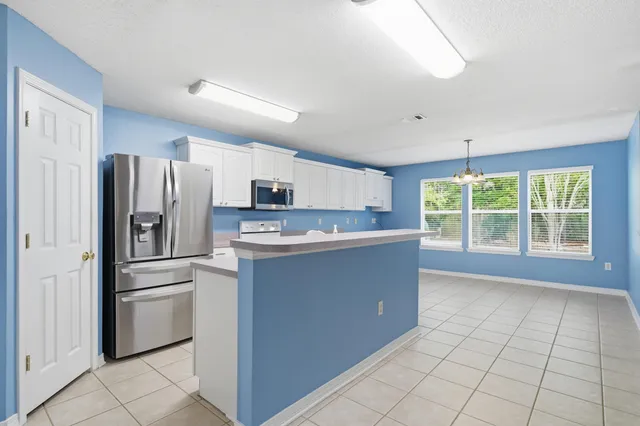 a kitchen with granite countertop white cabinets and window