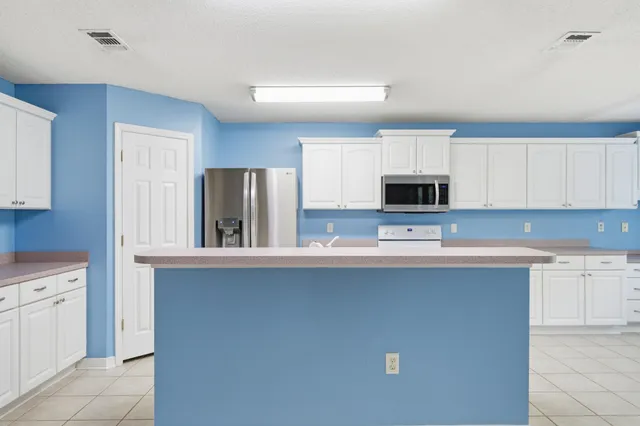 a view of an empty room with a fireplace and wooden floor