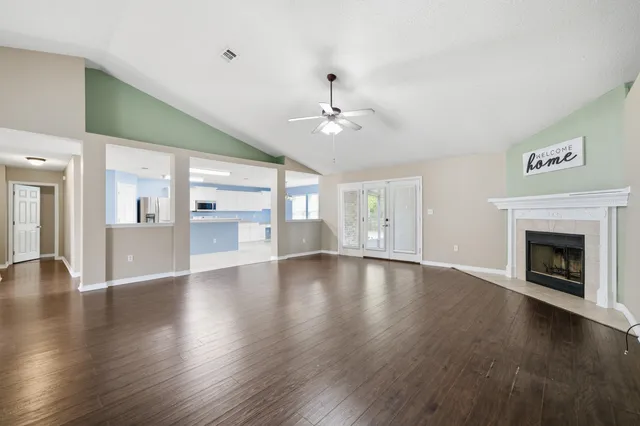 an empty room with wooden floor and windows