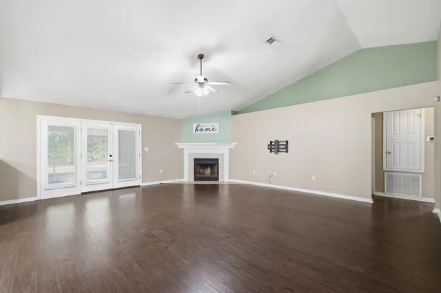 a view of an empty room with wooden floor