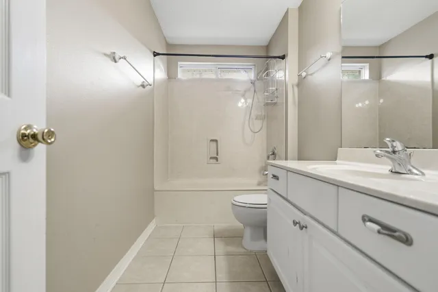 a view of an empty room with wooden floor and a ceiling fan
