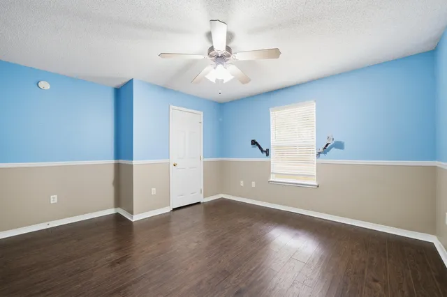 an empty room with wooden floor and window