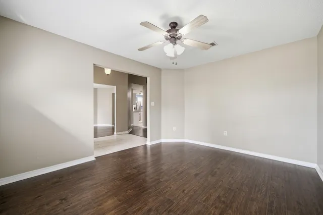 a view of a livingroom with wooden floor a chandelier and windows