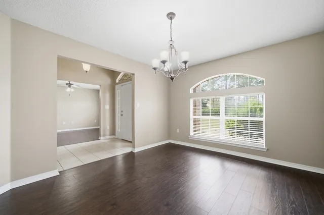 a view of a big room with wooden floor and chandelier