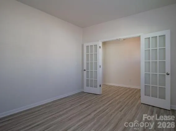 an empty room with wooden floor and white walls