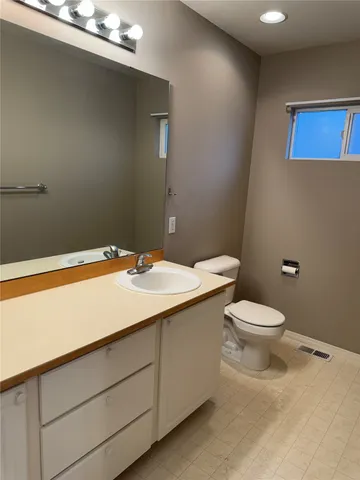 a bathroom with a sink a toilet and mirror