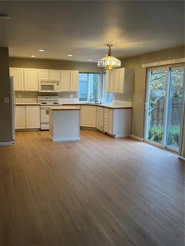 an open kitchen with granite countertop kitchen island wooden cabinets and stainless steel appliances