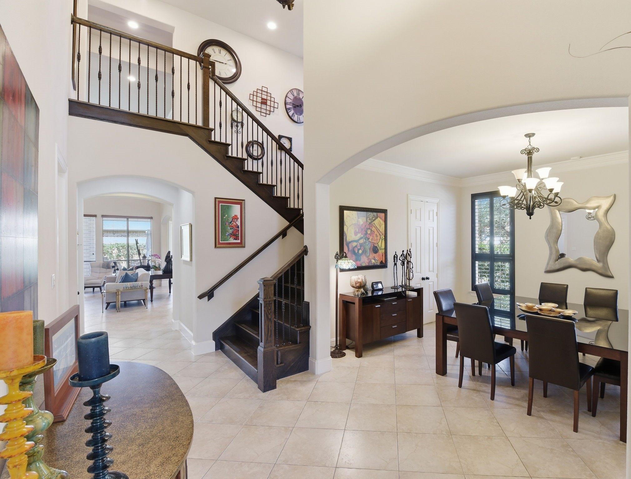 223 South Bauer Point Circle Spring, TX 77389 - Photo 11 of 50 The photo showcases a welcoming entryway with a stylish staircase and an open view into a bright living and dining area. The space is well-lit with modern chandeliers, neutral tile flooring, and contemporary decor, giving it a spacious and elegant feel.