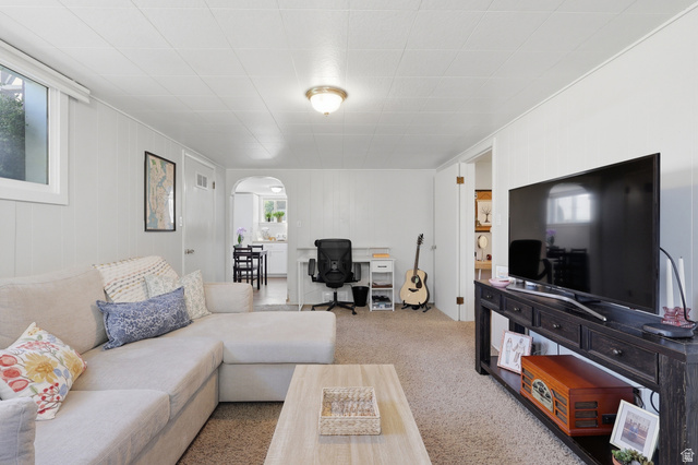 85 North 800 West Provo, UT 84601 - Photo 16 of 25 Carpeted living area featuring white paneling, an arched doorway, and a ceiling light fixture