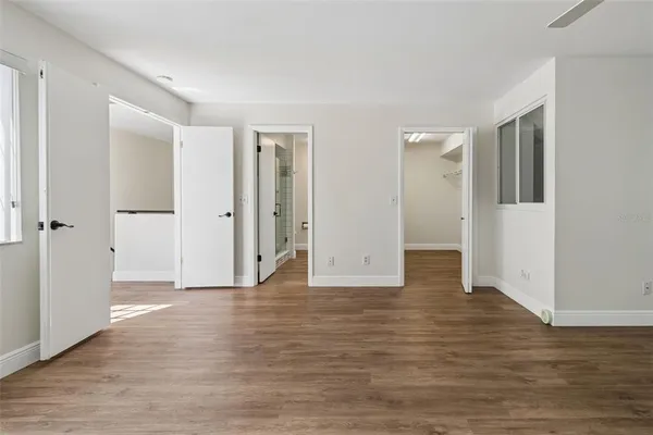 an empty room with wooden floor and ceiling fan