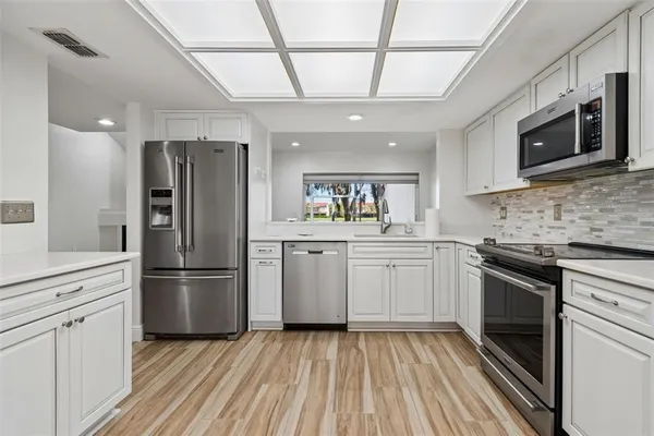 a kitchen with stainless steel appliances granite countertop a stove a sink and a microwave