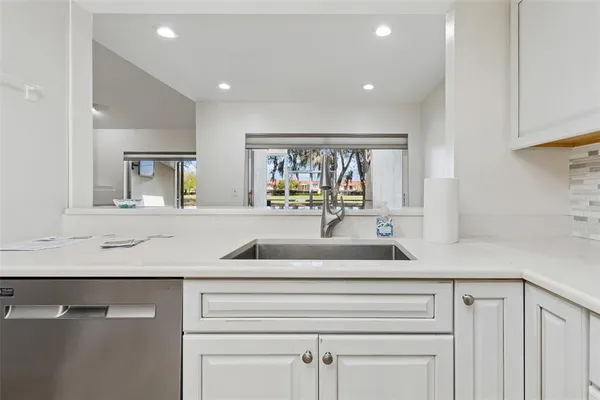 a view of an empty room with wooden floor fireplace and a window