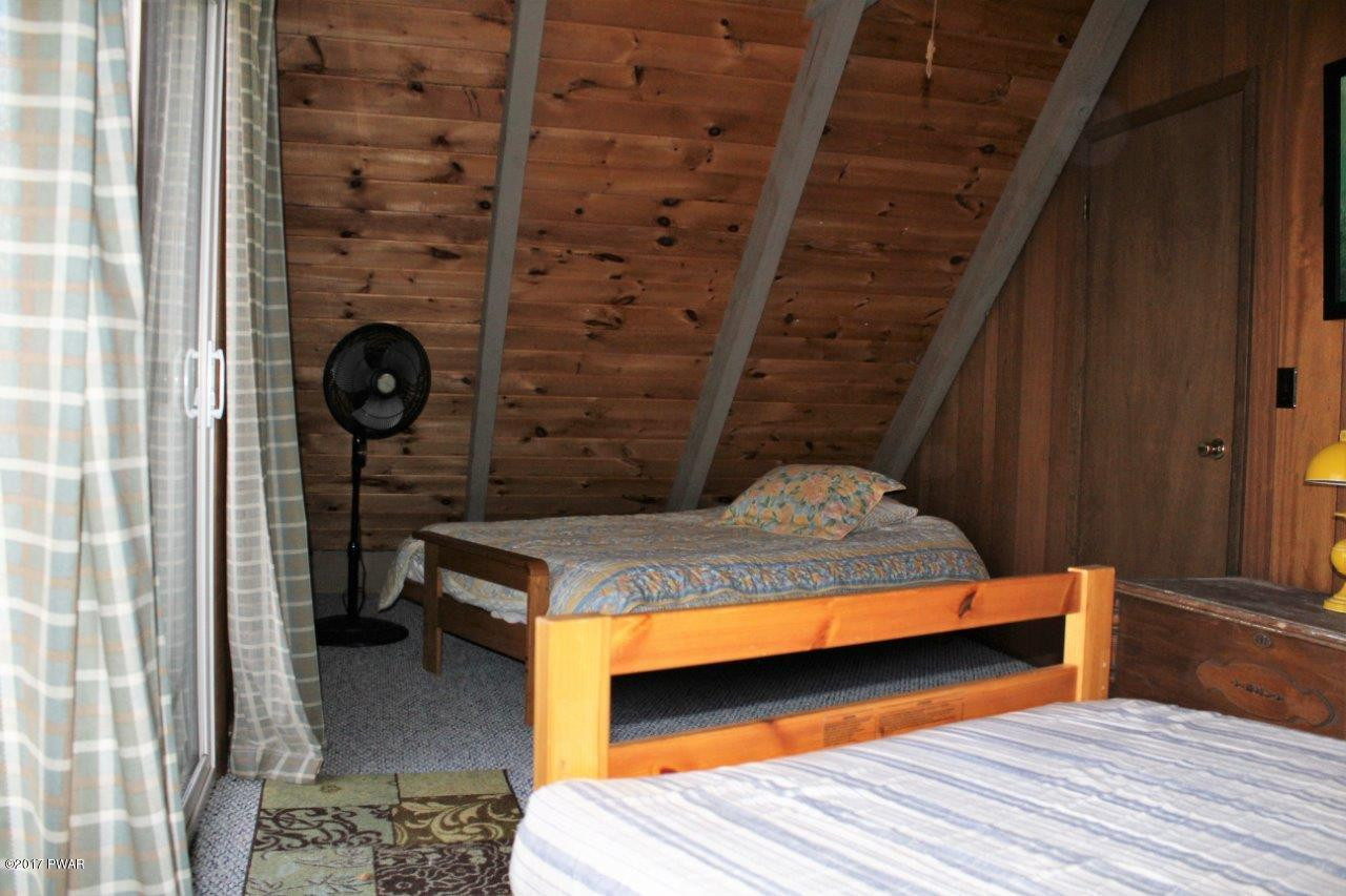 131 Maple Ridge Drive Hawley, PA 18428 - Photo 22 of 34 a bedroom with a bed and a table
