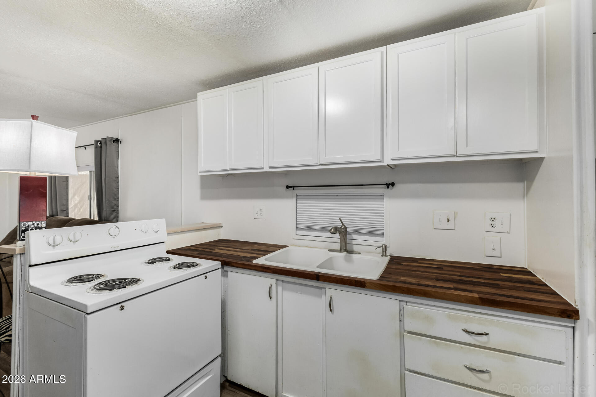 5201 West Camelback Road, Unit G264 Phoenix, AZ 85031 - Photo 5 of 16 a kitchen with a sink a stove and cabinets