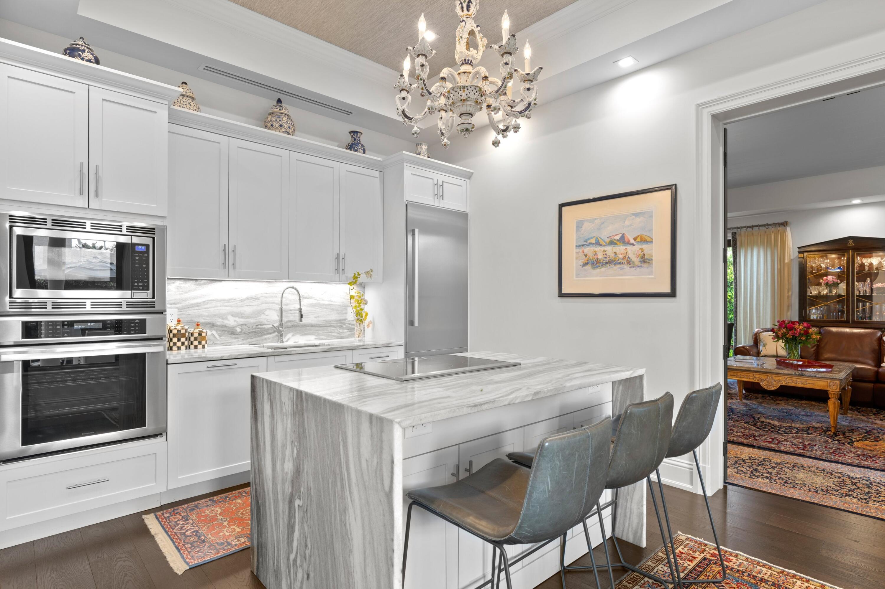 533 Westwood Road West Palm Beach, FL 33401 - Photo 11 of 43 a kitchen with stainless steel appliances granite countertop a stove top oven a sink dishwasher a dining table and chairs with wooden floor