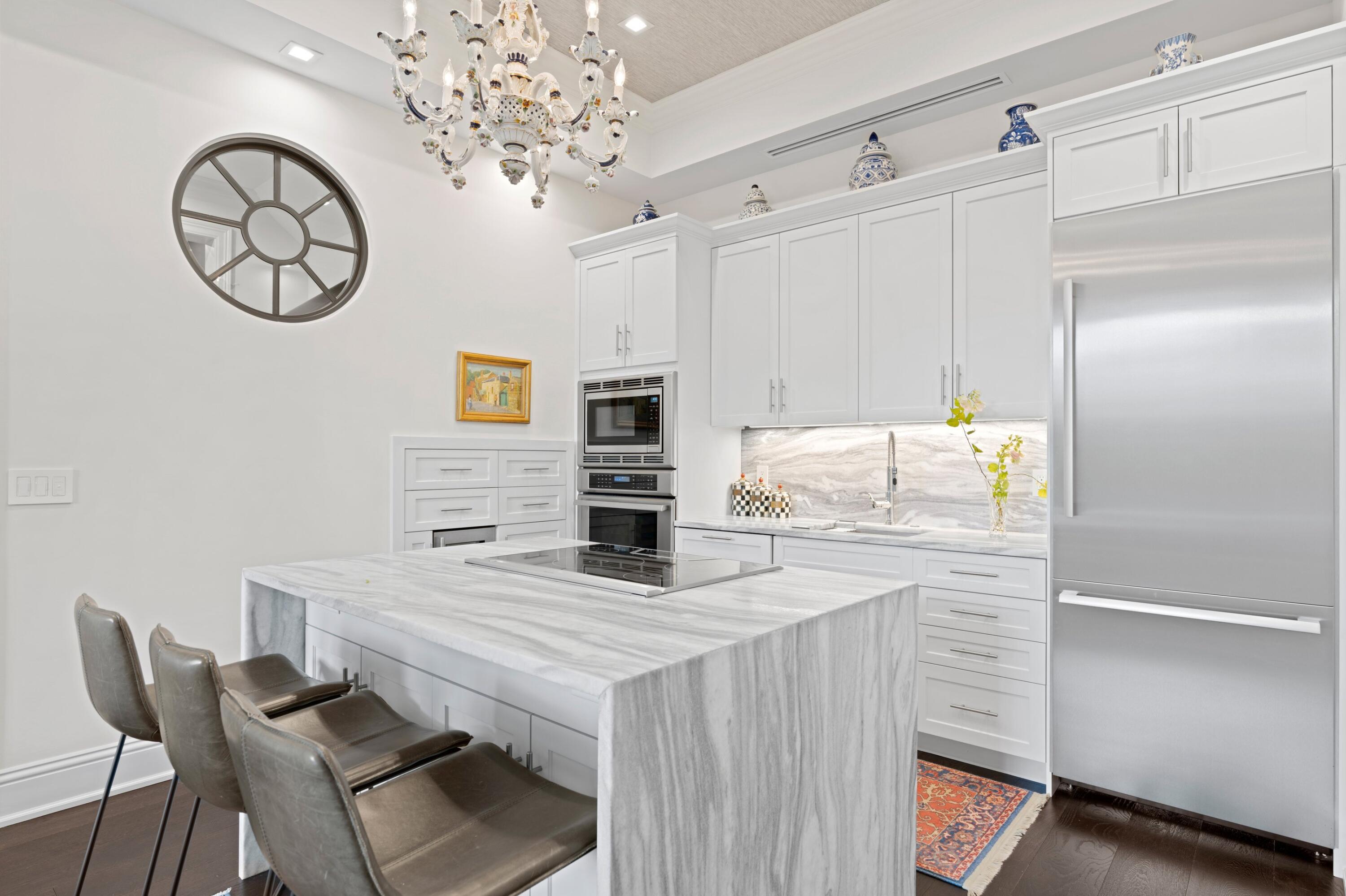 533 Westwood Road West Palm Beach, FL 33401 - Photo 13 of 43 a kitchen with stainless steel appliances kitchen island granite countertop a table chairs in it and wooden floors