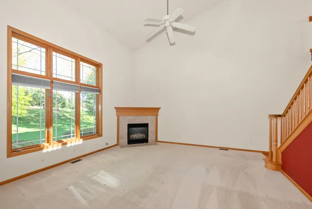 a view of an empty room with a fireplace and a window