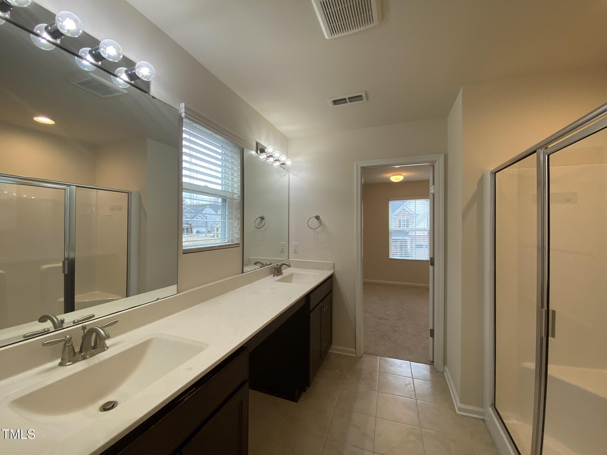 3545 Massey Ridge Court Raleigh, NC 27616 - Photo 28 of 38 a bathroom with double vanity sinks and a mirror