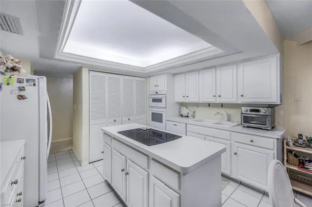 a kitchen with a sink a stove a refrigerator and cabinets